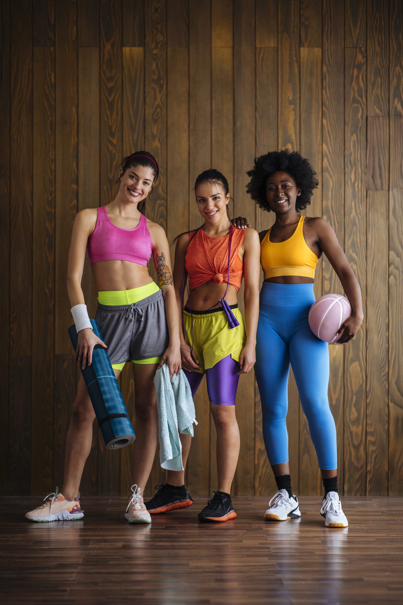 Women posing with workout gear indoors