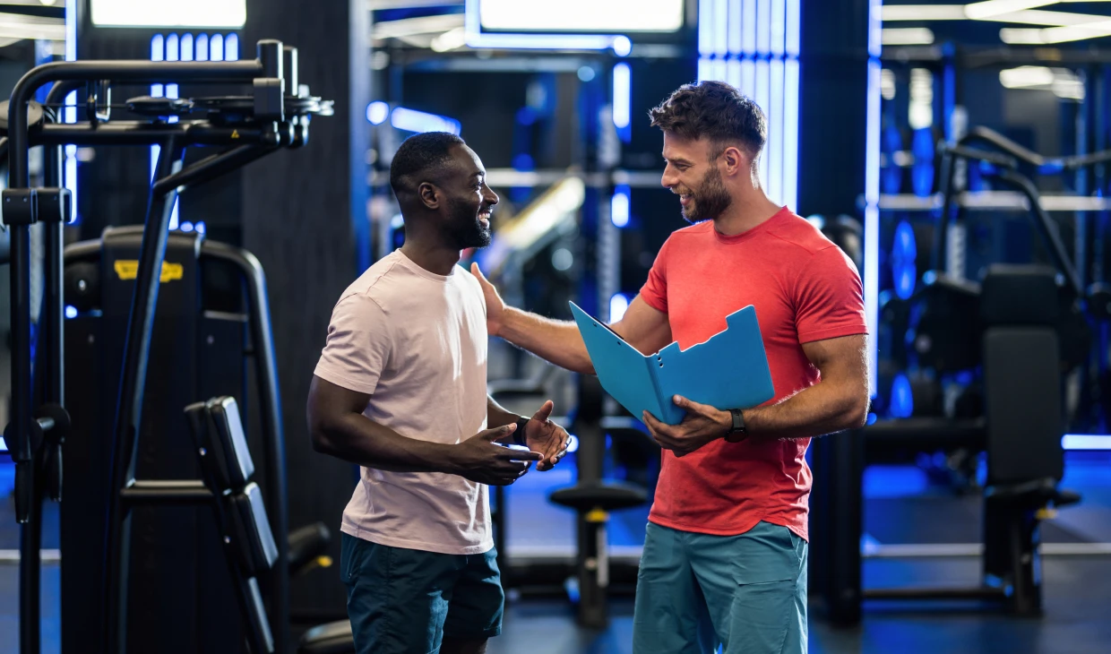 Men talking, holding fitness plan folder