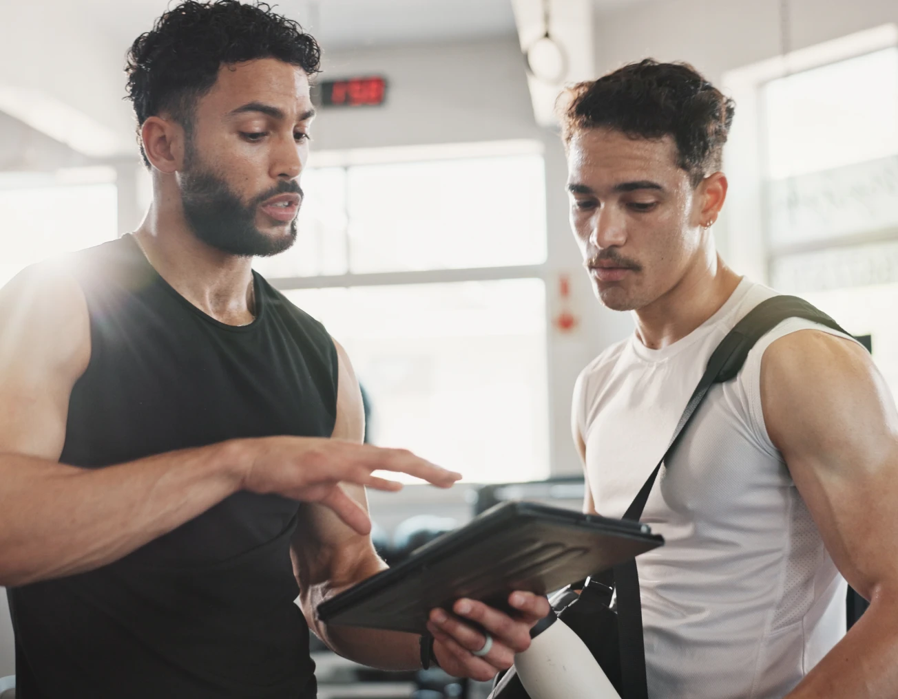 Gym trainer discussing workout plan with athlete.