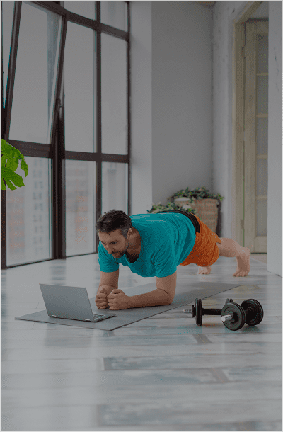 Man doing plank exercise with laptop